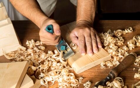 Home carpenter working with his bare hands wood